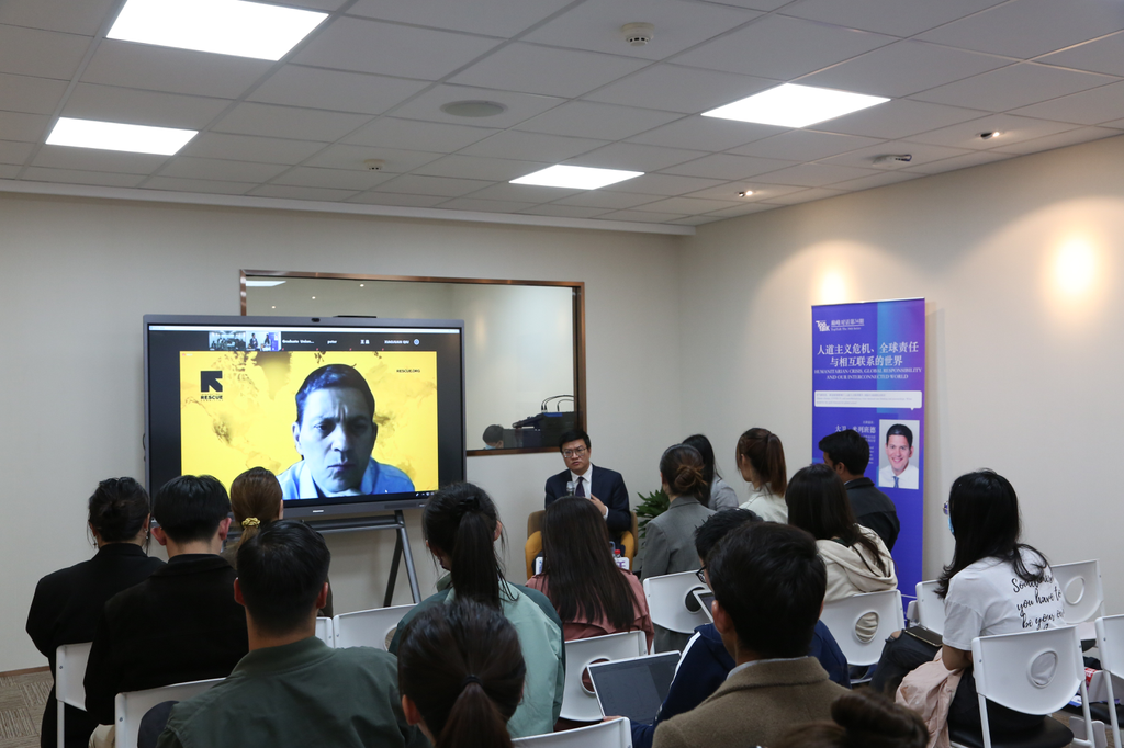 A group of people sitting in a room watching a presentationDescription automatically generated with low confidence